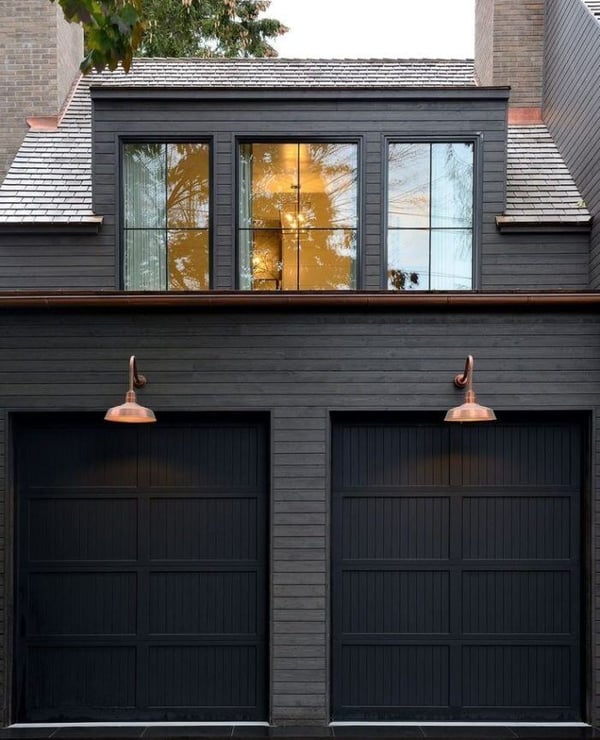 Copper gutter and copper sconces on a dark home exterior