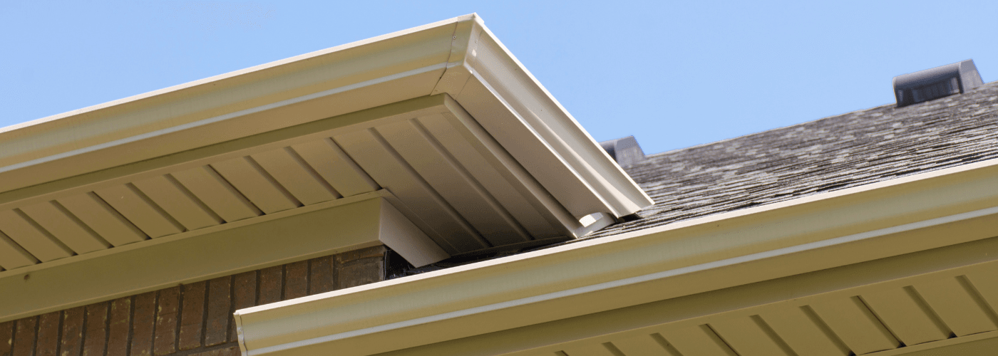 The top of a roofline on a brick home, showing the soffit and fascia of the home.