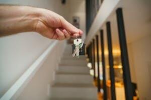 Person Holding Home Keys in Modren Interior