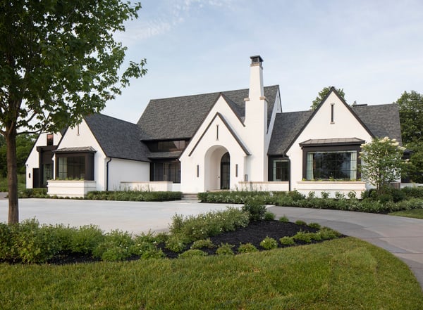 A modern minimalist white transitional house exterior with an arched entryway and black shingled roof