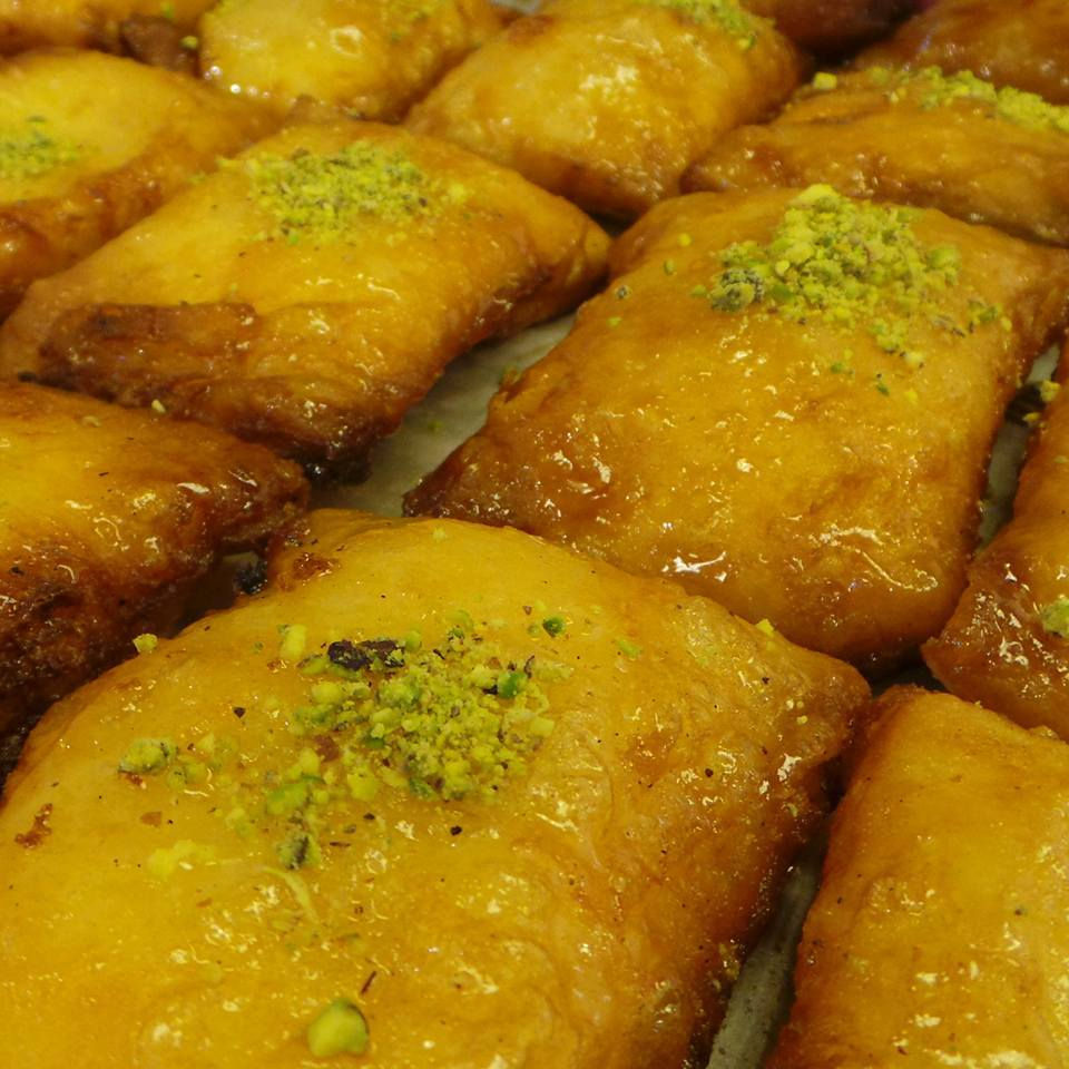 This is a picture of glazed Kellaj sprinkled with crushed pistachios. 