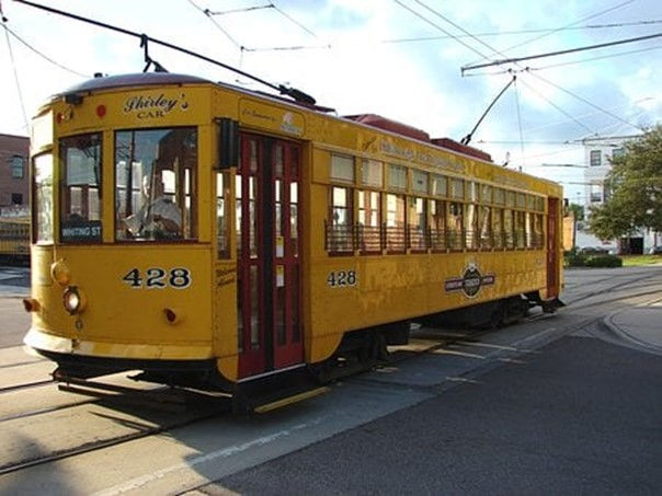 This is a picture of a yellow streetcar on a track.
