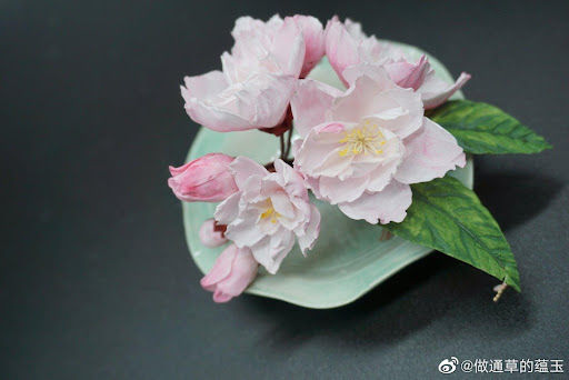 This is a picture of a pink rice paper flower against a black background.