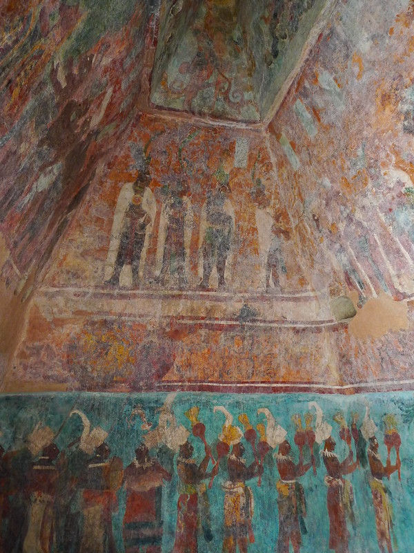 This is a picture of a mural found at Bonampak. There are pictures of ancient peoples against faded, earth-tone background colors, such as brown, red, orange, and turquoise. 