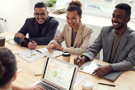 This is a picture of four business professionals sitting around a table, working on a project.