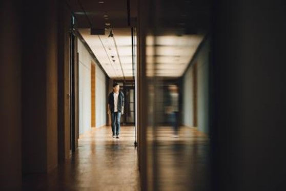 This is a picture of a man walking along a dark corridor.