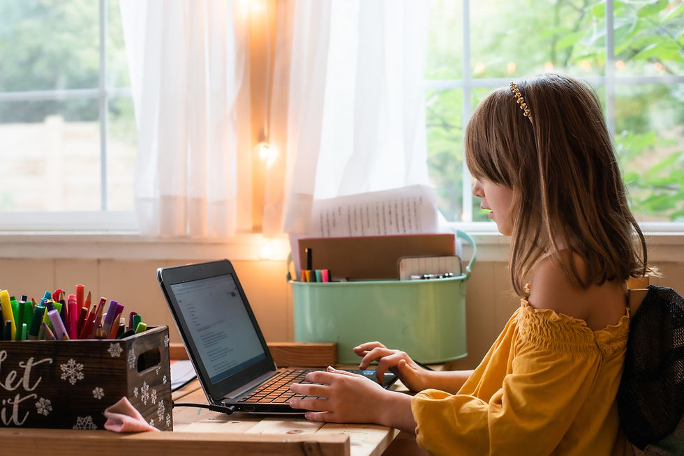 This is a picture of a young girl sitting at her laptop, completing an online course.