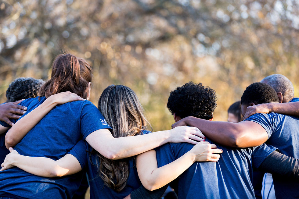 This is a picture of seven people standing in a circle with their arms interlocked. 
