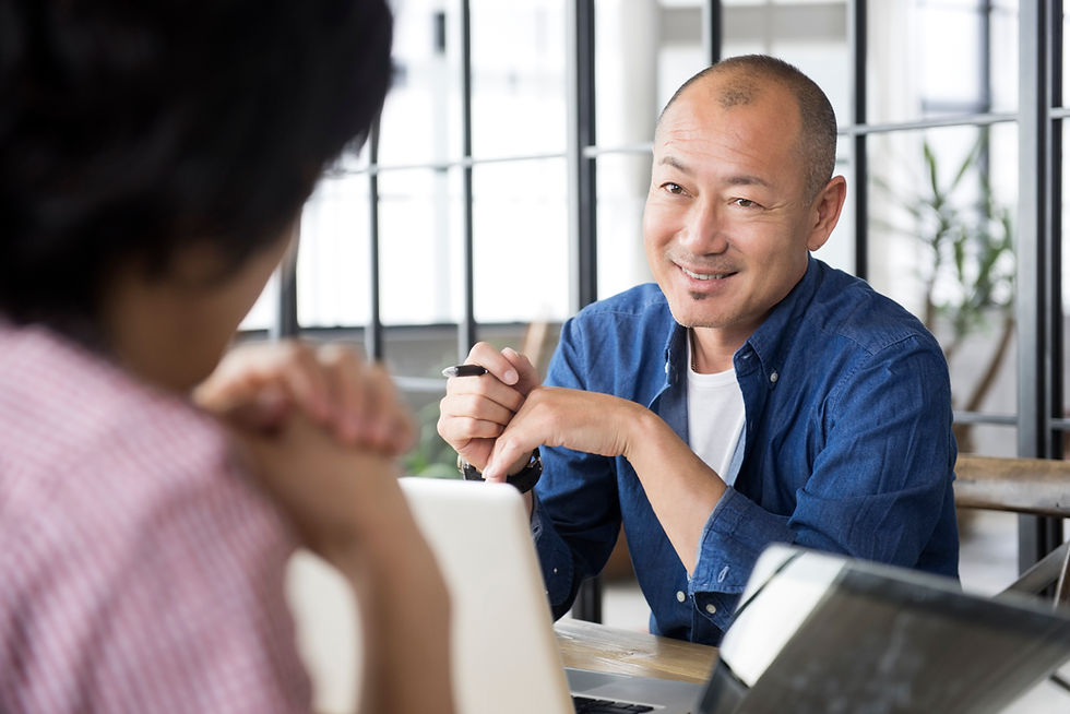 Balding man practicing English with a dark-haired woman in a pink shirt.