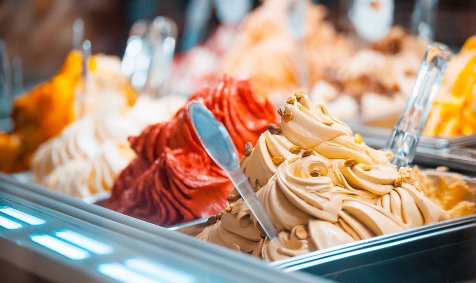 Several varieties of gelato in containers in a display case