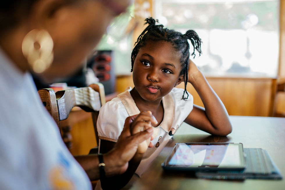 This is a picture of a Black mom and daughter. The mom is homeschooling her with the help of an iPad.