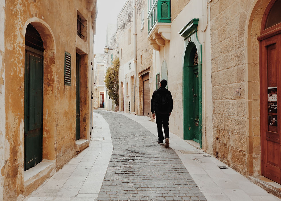 This is a picture of a man walking down a street in Italy.