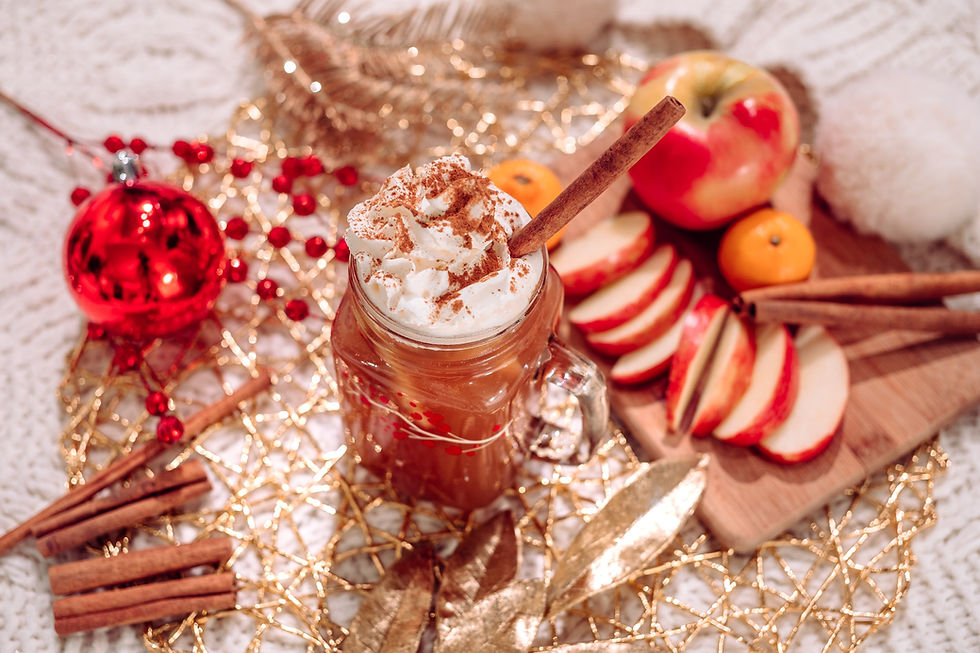 Hygge foods are sweet, savory, and indulgent. This image is hot chocolate with whipped-cream on top garnished with a cinnamon stick.