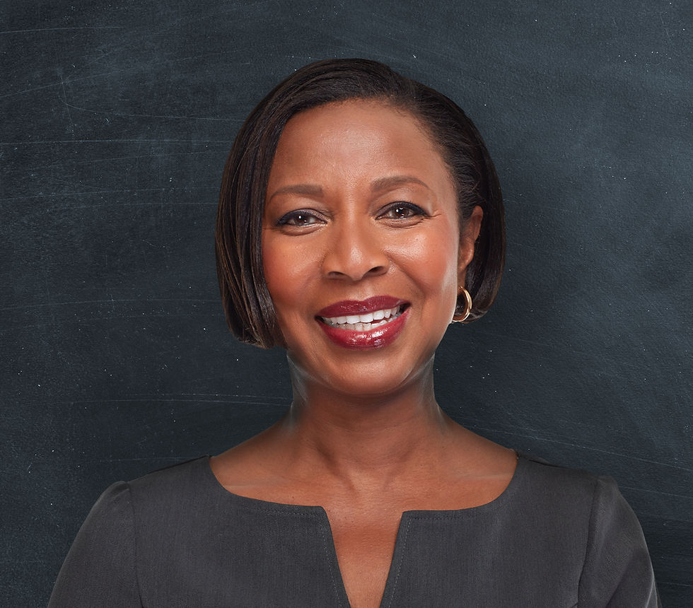 This is a portrait of a Black woman standing against a black chalkboard background. She has short, straight black hair, gold hoop earrings, and dark red lipstick. She's smiling, and she's wearing a fancy black top.