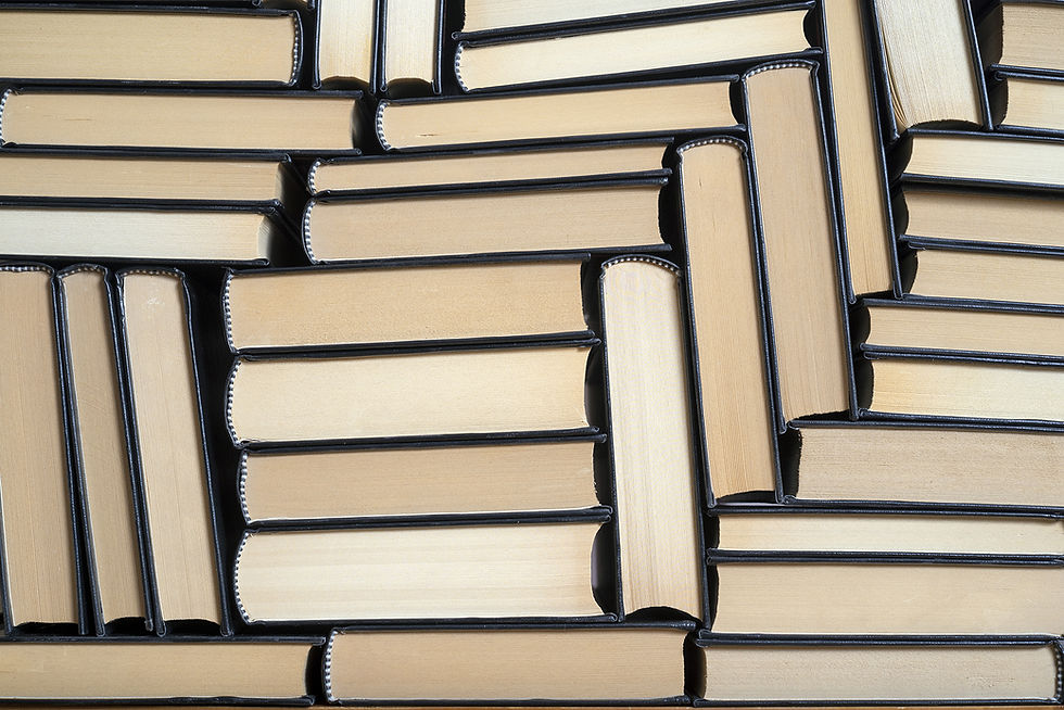 This is a picture of the side view of multiple stacks of books.