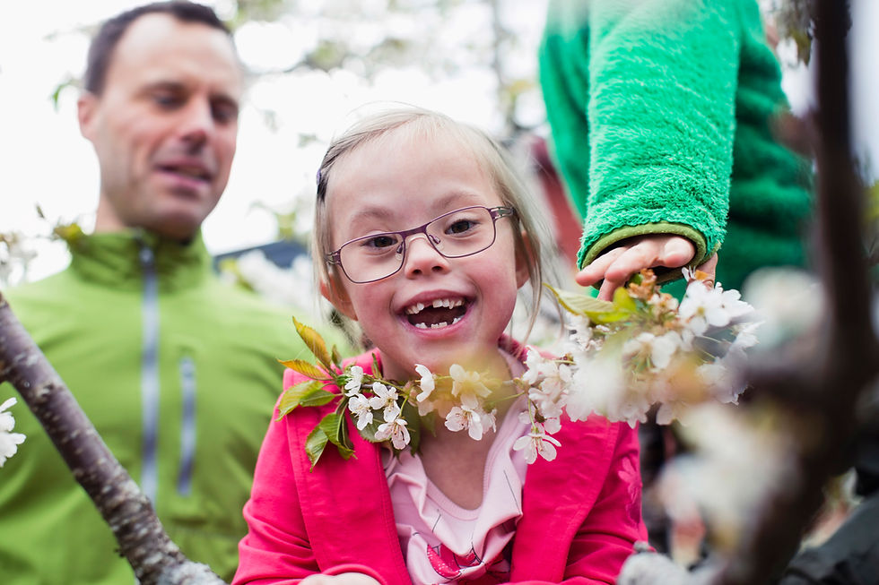 This is a picture of a girl with Down Syndrome holding a tree branch. 
