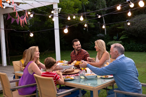 family gathered around a dinner table in the backyard